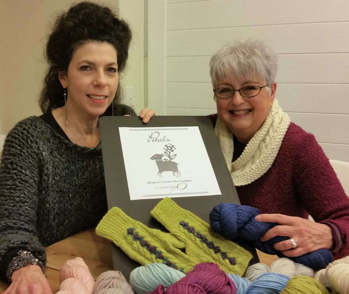 Nancy O'Connell, right, owner of nancy O, with Ridgefield artist Amy Bock, who designed the labels for the nancy O private-label yarns. Shown is a replica of the label for one of the two new yarns.