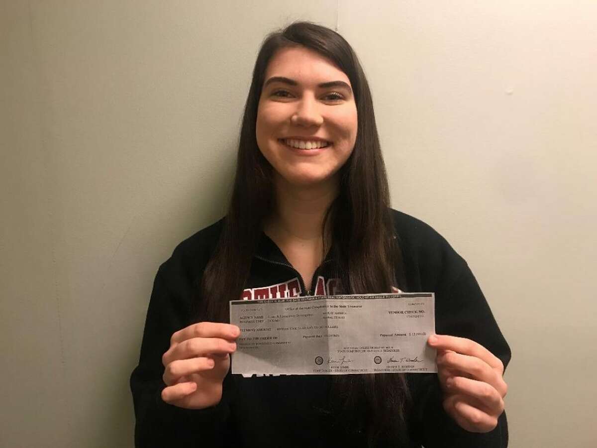Ridgefield High School graduate Abby Fennell with a $15,000 grant check that the state's Office of Economic and Community Development awarded to CHIRP. Ridgefield's concert park series returns in May for its 18th year.