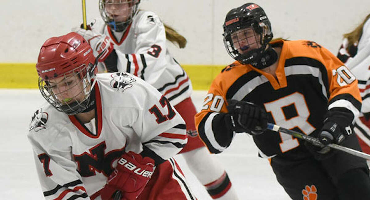 New Canaan's Sadie Frame controls the puck in the neutral zone, as Ridgefield/Danbury's Rebecca Gartner chases during a girls hockey game at the Darien Ice House on Monday, Jan. 28. - Dave Stewart/Hearst Connecticut Media photo