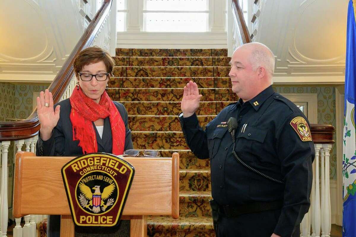 Lt. Shawn Platt of the Ridgefield Police Department is sworn in as captain by Town Clerk Wendy Lionetti during a ceremony at Lounsbury House Thursday, Jan. 17.