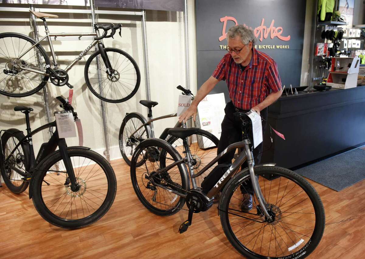 Robert Fullem, owner of The Downtube Bicycle Works, displays an e-bike from Trek, which he sells at his Madison Avenue shop on Tuesday, June 18, 2019, in Albany, N.Y. The bike uses a battery-powered pedal assistance system. (Will Waldron/Times Union)