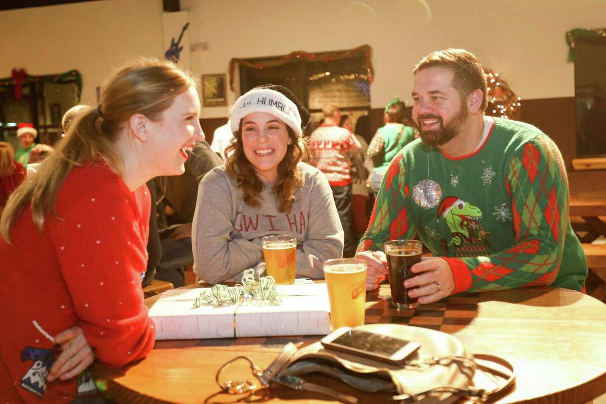 The Woodlands residents Lindsey Schulz, left, and Sarah and Jeff Wilkins chat while donning ugly Christmas sweaters for a contest during the Southern Star Christmas Party on Friday, Dec. 22, 2017, at the Southern Star Brewing Company in Conroe.