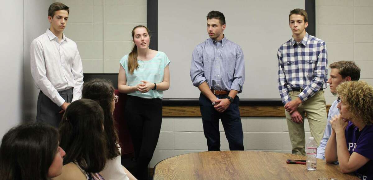 Westhill High School seniors Julien Matrullo, Kate Williams, Zach Rubin, and Christopher Matrullo presented their app, PoliTalk, to Westhill Principal Michael Rinaldi at the school on June 14.