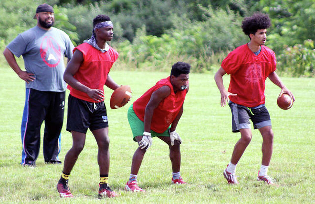 Alton assistant coach Mel Sheppard keeps on eye on players (from left) Kavontay Samelton, Dasani Stewart and Andrew Jones during a drill Tuesday at Alton High School.