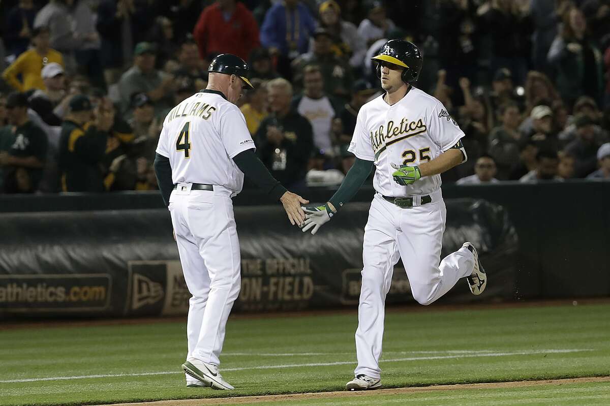 Oakland Athletics' Stephen Piscotty (25) is congratulated by third base coach Matt Williams (4) after hitting a three-run home run against the Baltimore Orioles during the sixth inning of a baseball game in Oakland, Calif., Tuesday, June 18, 2019. (AP Photo/Jeff Chiu)