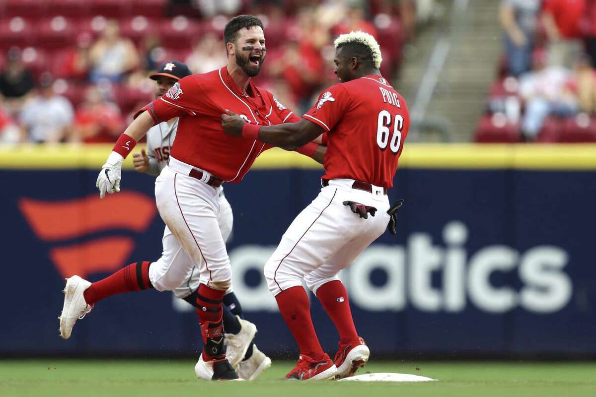 Cincinnati Reds' Jesse Winker, left, celebrates with Yasiel Puig, right, after hitting the game-winning RBI-single in the ninth inning of a baseball game against the Houston Astros, Wednesday in Cincinnati.