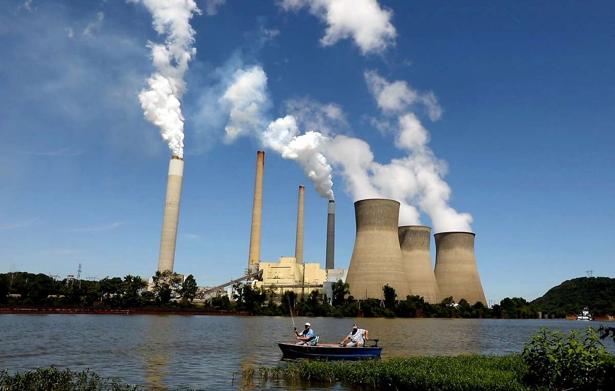 Fishermen drift by the John E. Amos coal-fired power plant operating on the banks of the Kanawha River near Winfield, W.V. (Carolyn Cole/Los Angeles Times/TNS)
