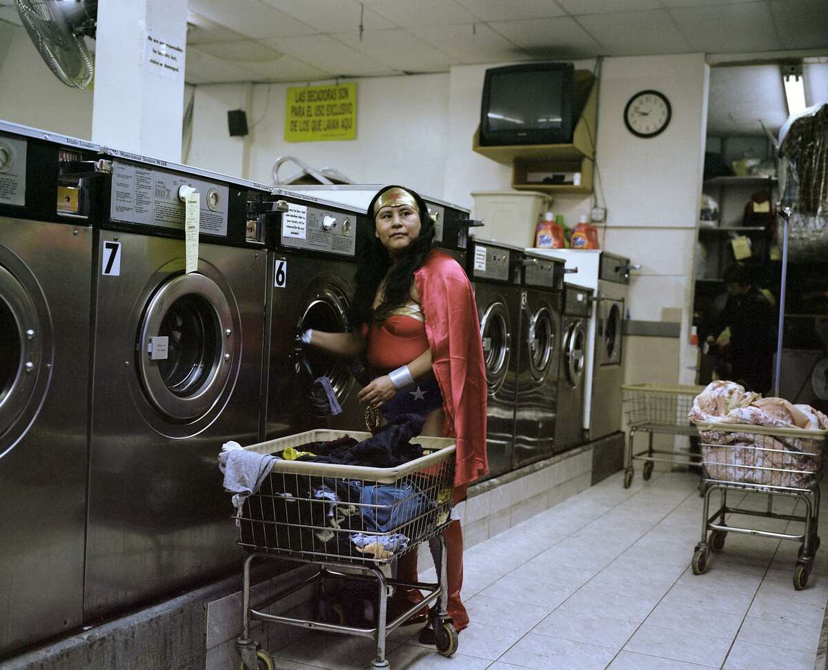 Dulce Pinzon's photograph of Maria Luisa Romero, an immigrant from Puebla who works in a laundromat and sends $150 home to her family every week, is part of the "Men of Steel, Women of Wonder" exhibit at the San Antonio Museum of Art.