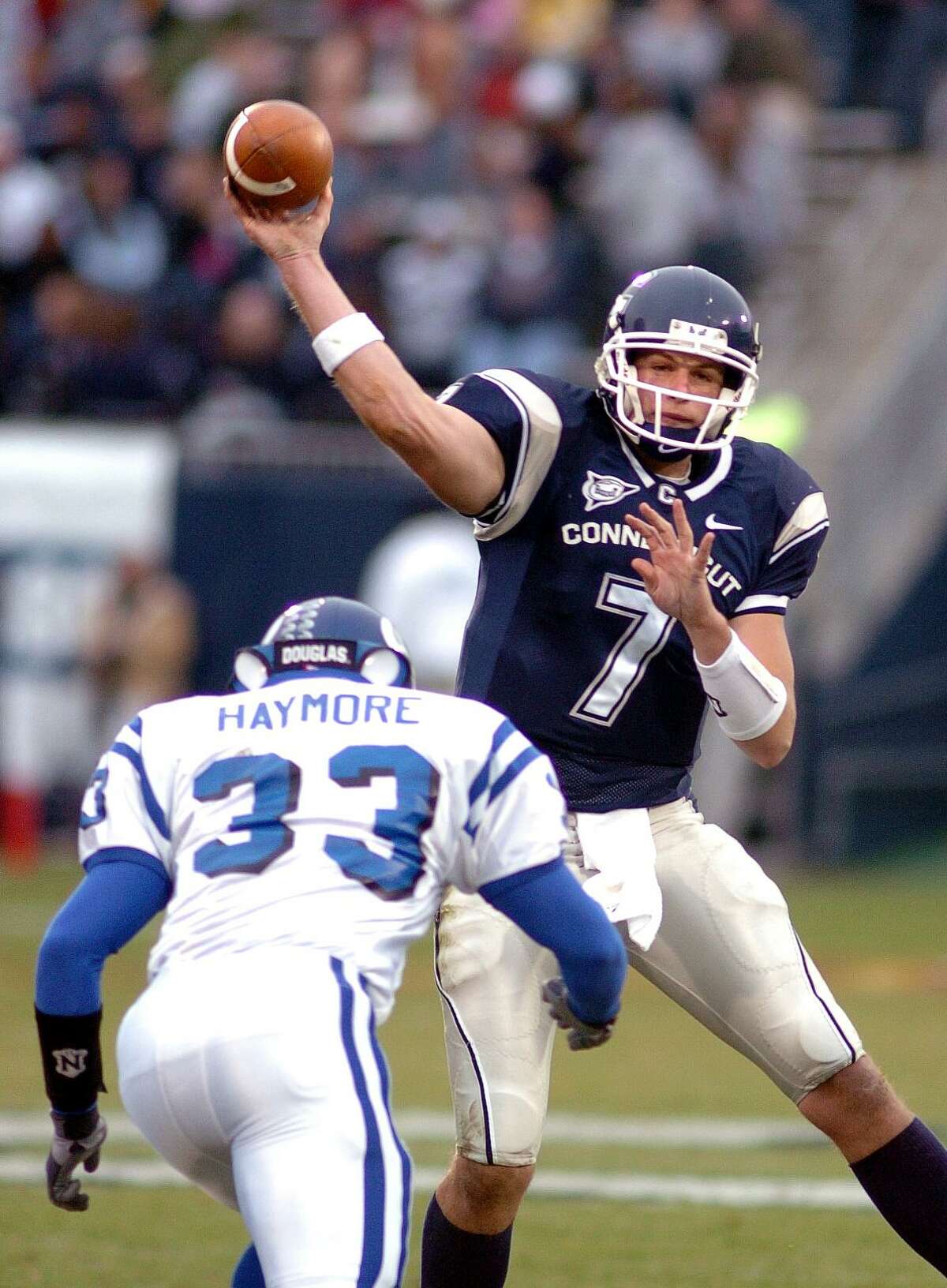 UConn quarterback Dan Orlovsky completes a pass as Buffalo’s Laron Haymore defends in a November 2004 game.