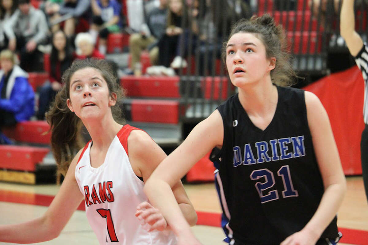 Darien's Aerin Bowman (21) and New Canaan's Quinn McKiernan battle for position during a free throw in Saturday's girls basketball game at NCHS. - Terry Dinan photo