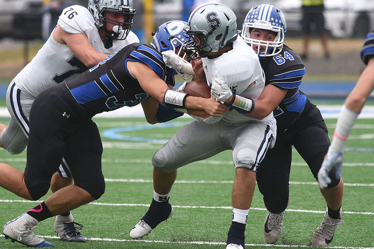Darien's Connor Fay (64) and Alex Quirk wrap up Staples; Timmy Luciano during the Blue Wave's 24-0 victory on Saturday, Oct. 6. - Dave Stewart photo