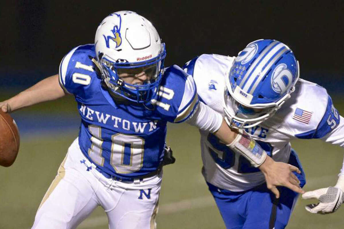 Darien's Will Bothwell tackles Newtown QB Luke Melillo during the Class LL quarterfinals Tuesday night in Newtown. - H John Voorhees III photo