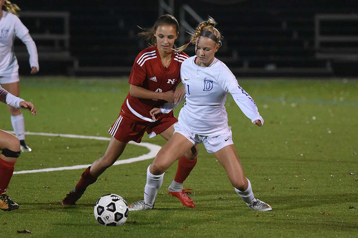 Darien's Lauren Sulger (11) and New Canaan's Sophie Potter battle for the ball during the FCIAC girls soccer semifinals Monday night at Wilton High School. - Dave Stewart photo