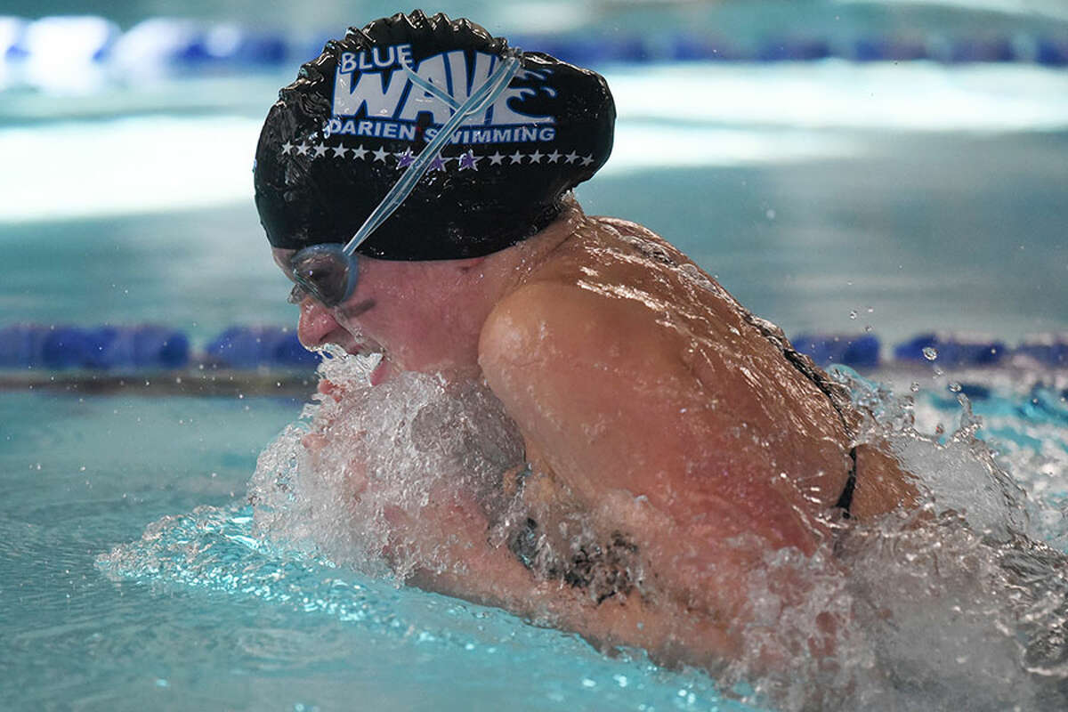 Darien's Kaitlyn Holmes competes in the 100 breaststroke during the Blue Wave's win over rival New Canaan Wednesday at the Darien YMCA. - Dave Stewart photo