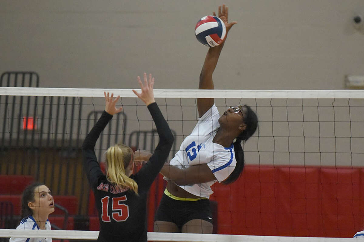 Darien's Hassana Arbubakrr puts down a shot during the Wave's 3-0 win over the rival Rams in New Canaan on Monday. - Dave Stewart photo