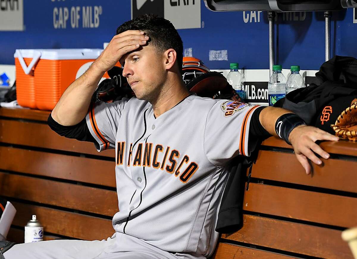Buster Posey #28 of the San Francisco Giants sits in the dugout in the fifth inning of the game against the Los Angeles Dodgers at Dodger Stadium on June 19, 2019 in Los Angeles.