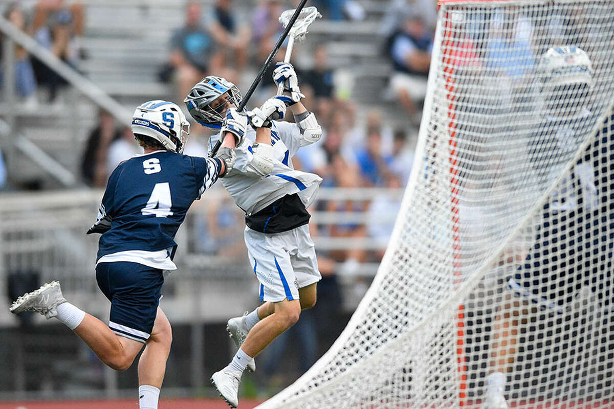 Staples' Jack Dorsey defends as Darien's Michael Minicus fires a shot on Staples goalie Tim Luciano (91) in a CIAC boys lacrosse Class L state tournament semifinal game at Brien McMahon High School on Wednesday night. - Matthew Brown/Hearst Connecticut Media