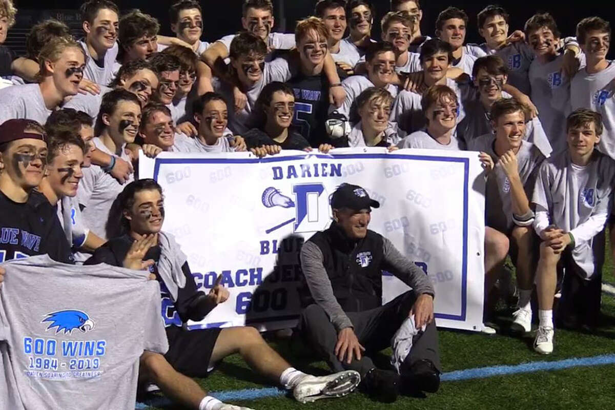 Darien coach Jeff Brameier (center) poses with the rest of the Darien boys lacrosse players after they defeated Wilton 18-6 for Brameier's 600th career victory as head coach. - Sean Patrick Bowley/Hearst Connecticut Media