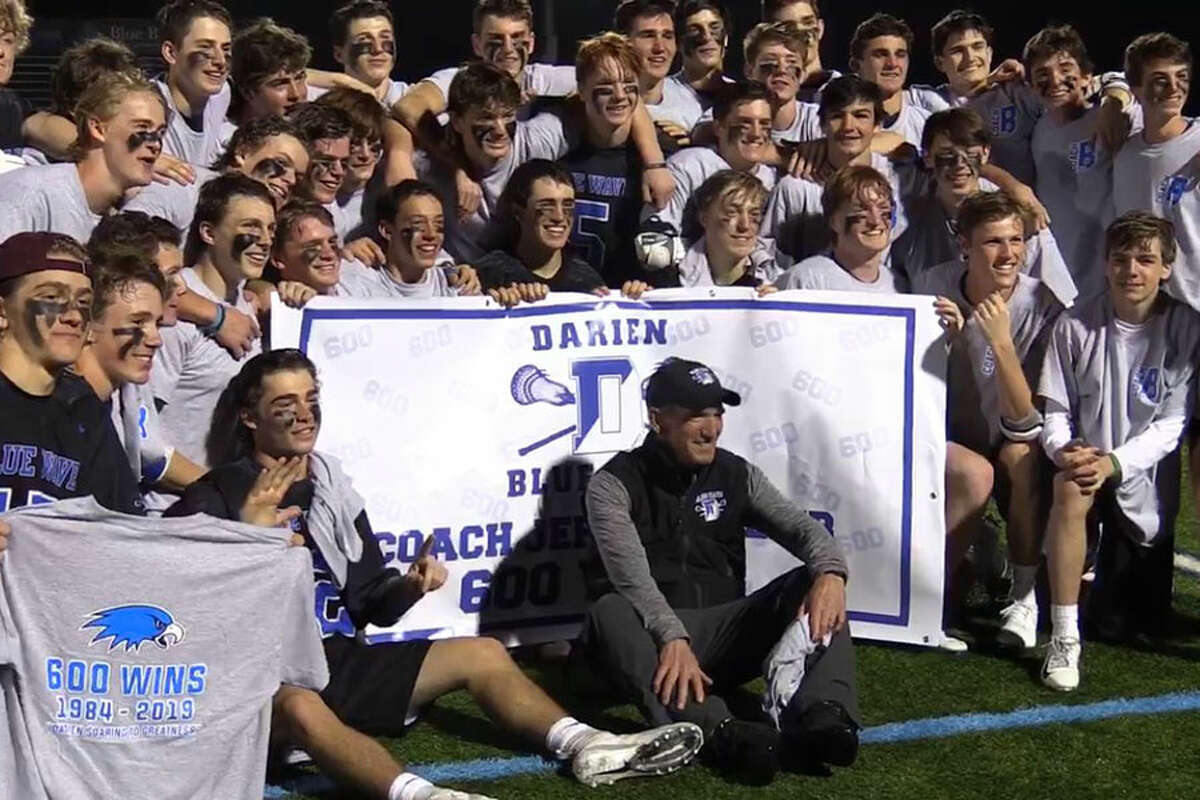 Darien coach Jeff Brameier (center) poses with the rest of the Darien boys lacrosse players after they defeated Wilton 18-6 for Brameier's 600th career victory as head coach. — Sean Patrick Bowley/Hearst Connecticut Media