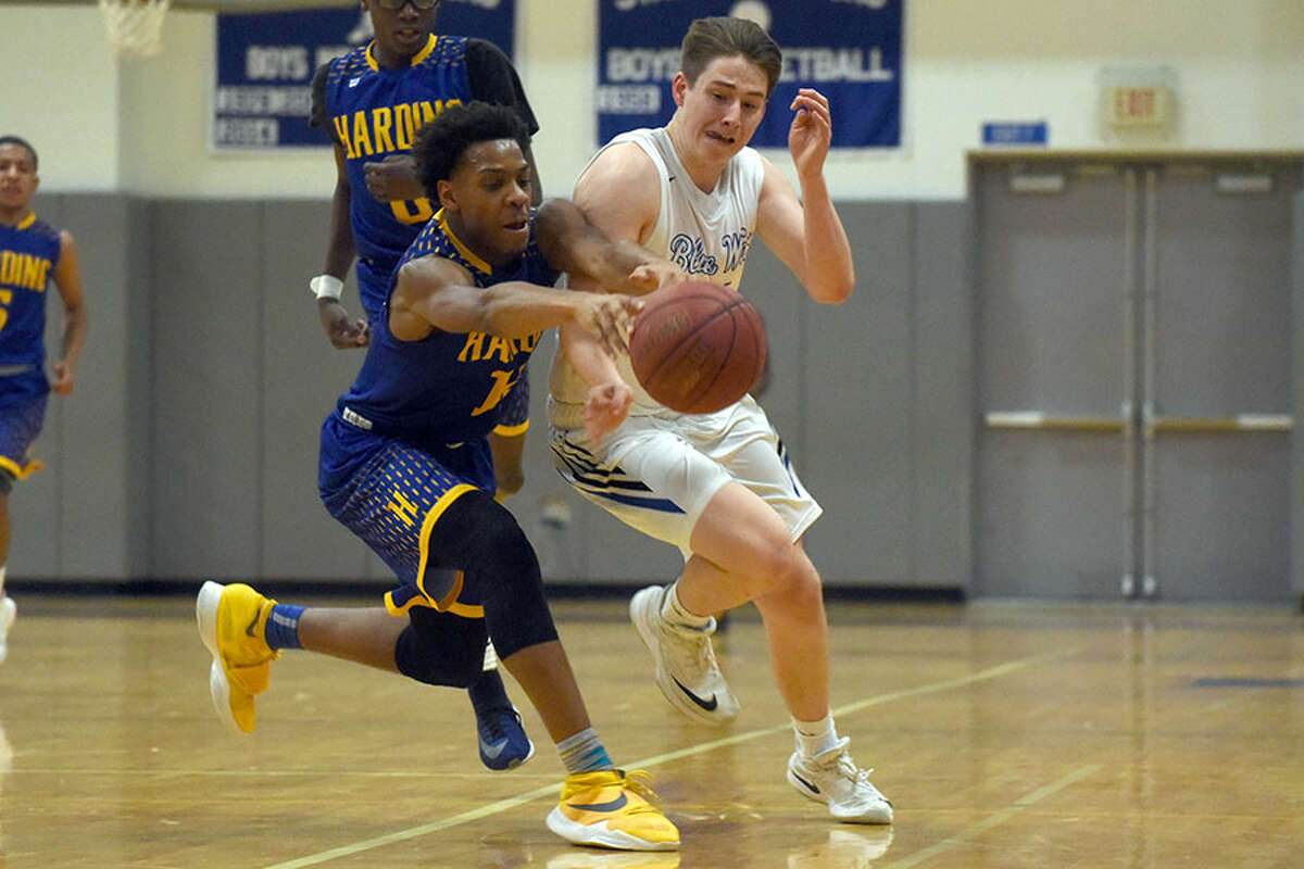 Darien's Ryan Darby and Harding's Markis Christie battle for a loose ball during a boys basketball game at Darien High School on Monday, Feb. 11. - Dave Stewart/Hearst Connecticut Media photo