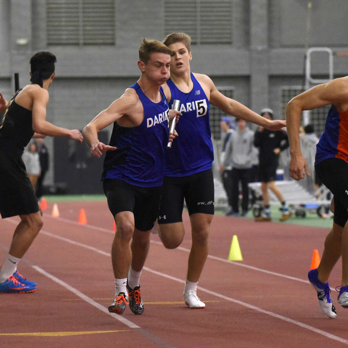Darien's Jack Holly takes the baton from teammate Austin Dehmel during the 4x400 relay at the FCIAC indoor track and field championships in New Haven on Thursday, Jan. 31. - Dave Stewart/Hearst Connecticut Media photo