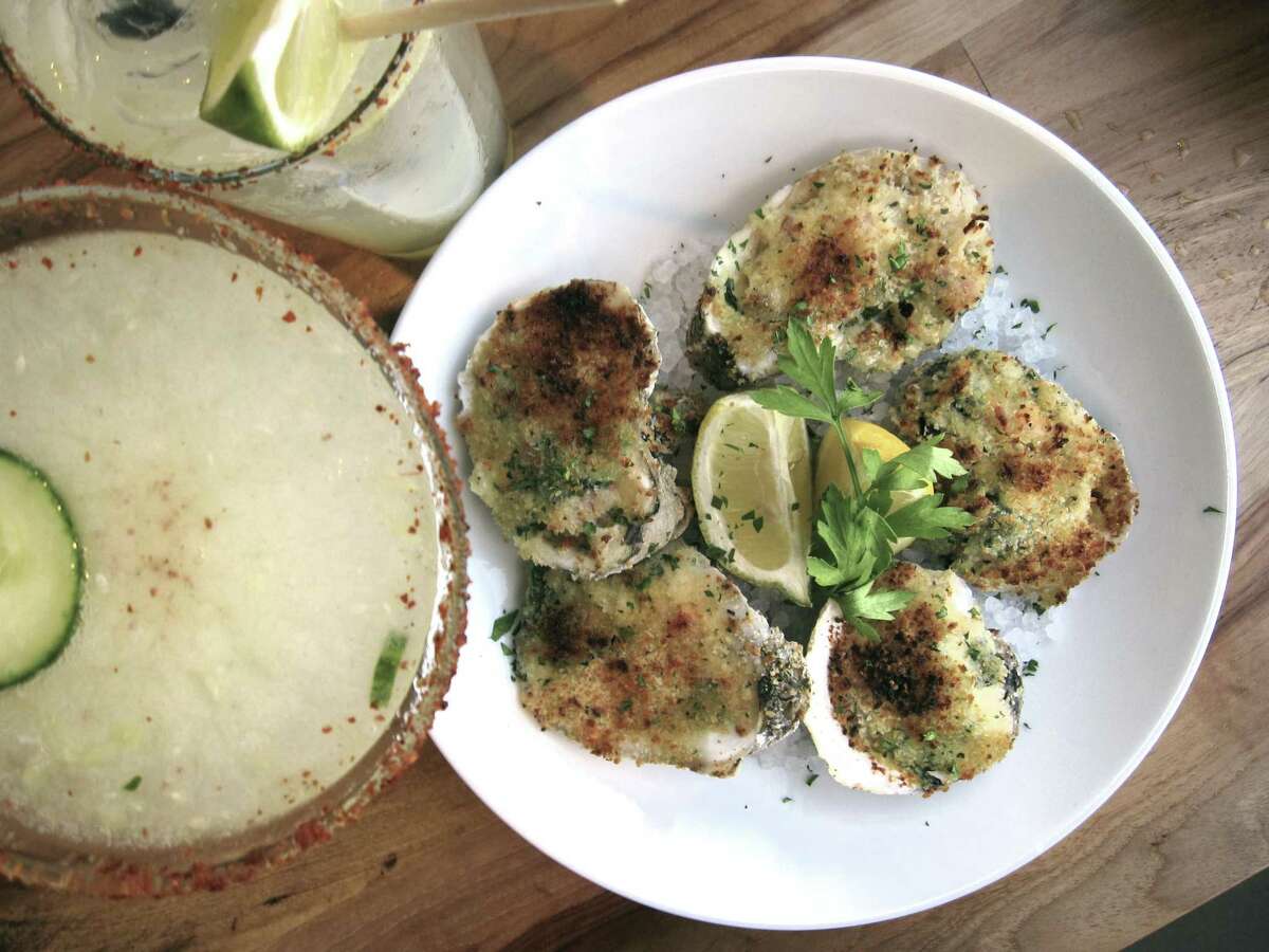 Oysters Rockefeller with Parmesan, garlic breadcrumbs and bacon share table space with a Cucumber Kaiparasohka cocktail and a spicy margarita at Silo Terrace Oyster Bar.