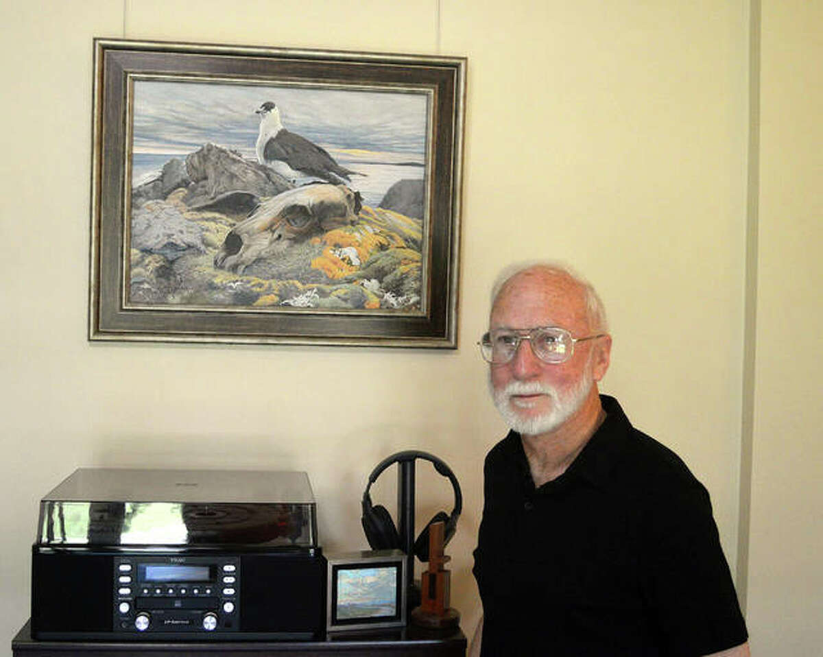 Wildlife artist Brent Langley poses with one of his paintings, depicting a polar bear and a jaeger (a sea bird) from a 2012 visit to Spitzbergen.
