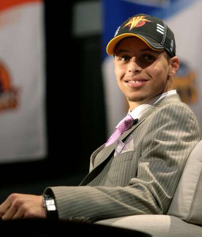 Golden State Warriors top draft pick Stephen Curry poses with his new jersey  during a news conference at the Warriors headquarters in Oakland, Calif.,  Friday, June 26, 2009. Curry, a guard from