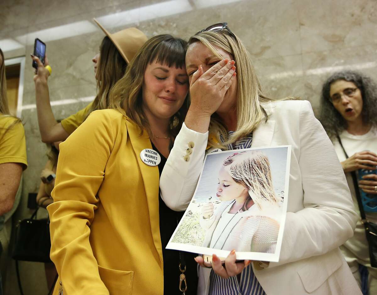 Jessica Purciful , left, and Angela Hicks, right, who both opposed a measure that would give public health officials oversight of doctors that may be giving fraudulent medical exemptions from vaccinations console each other after the bill SB276 was approved by the Assembly Health Committee at the Capitol in Sacramento, Calif., Thursday, June 20, 2019. (AP Photo/Rich Pedroncelli)
