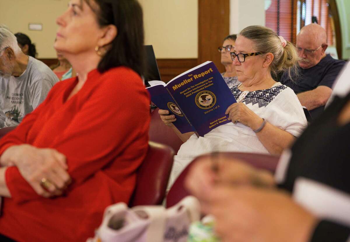 Marsha Canright reads along during the second day of a four-day-long reading of the Mueller Report by the group Public Reads - Galveston inside the Rosenberg Library in Galveston, Thursday, June 20, 2019.