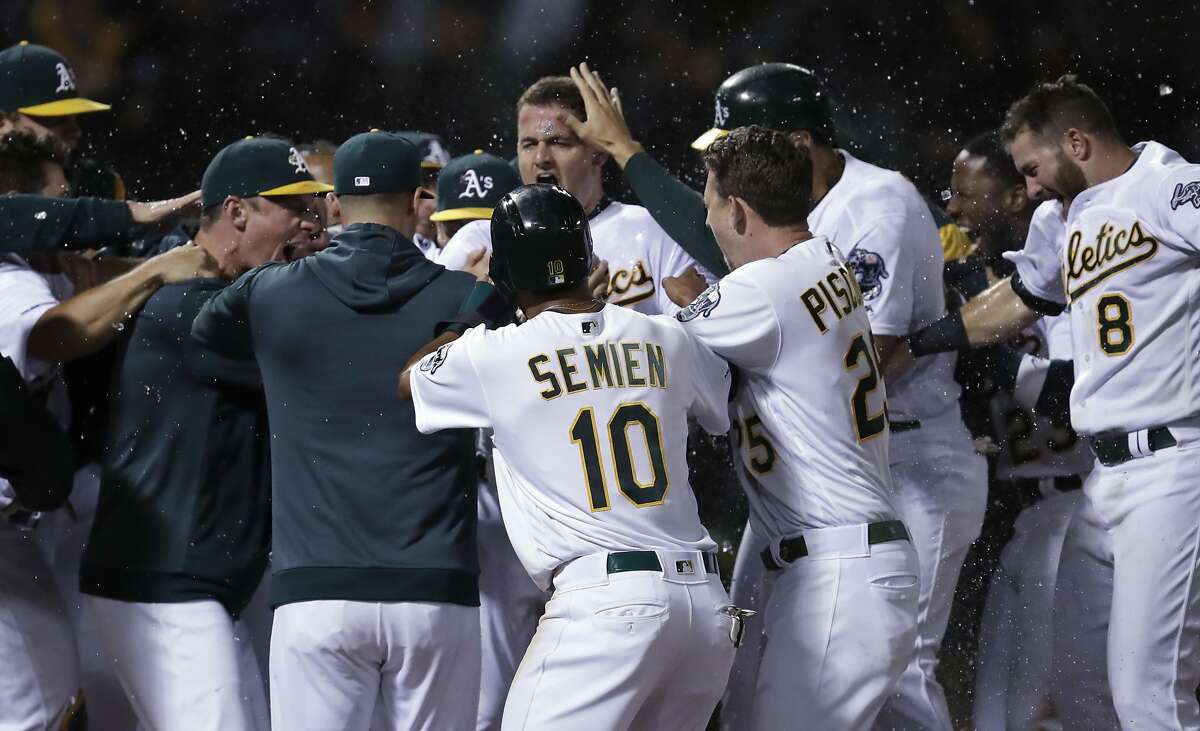 Oakland Athletics' Matt Chapman, center, celebrates with teammates after hitting a three-run home run off Tampa Bay Rays' Diego Castillo in the ninth inning of a baseball game Thursday, June 20, 2019, in Oakland, Calif. Oakland won 5-4. (AP Photo/Ben Margot)