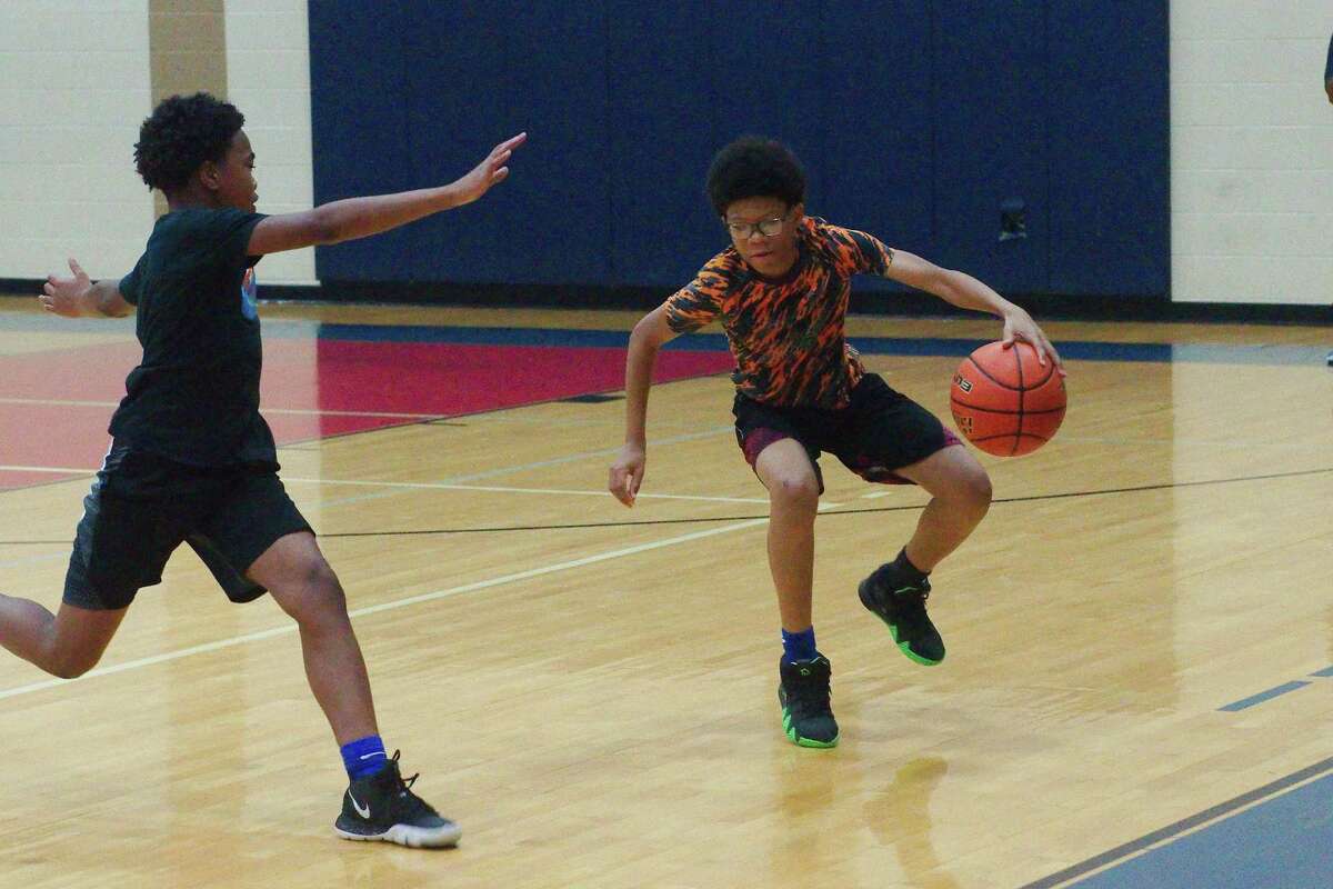 Nehemiah Richardson (left) and David Mitchell participate in a one-on-one drill at the Dawson summer basketball camp.