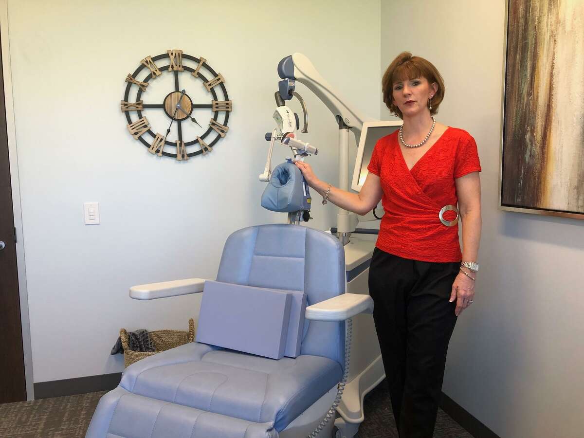 Dr. Kimberly Cress, MD, and the device she uses in her Katy psychiatric practice for Transcranial Magnetic Stimulation, a treatment for clinical depression.