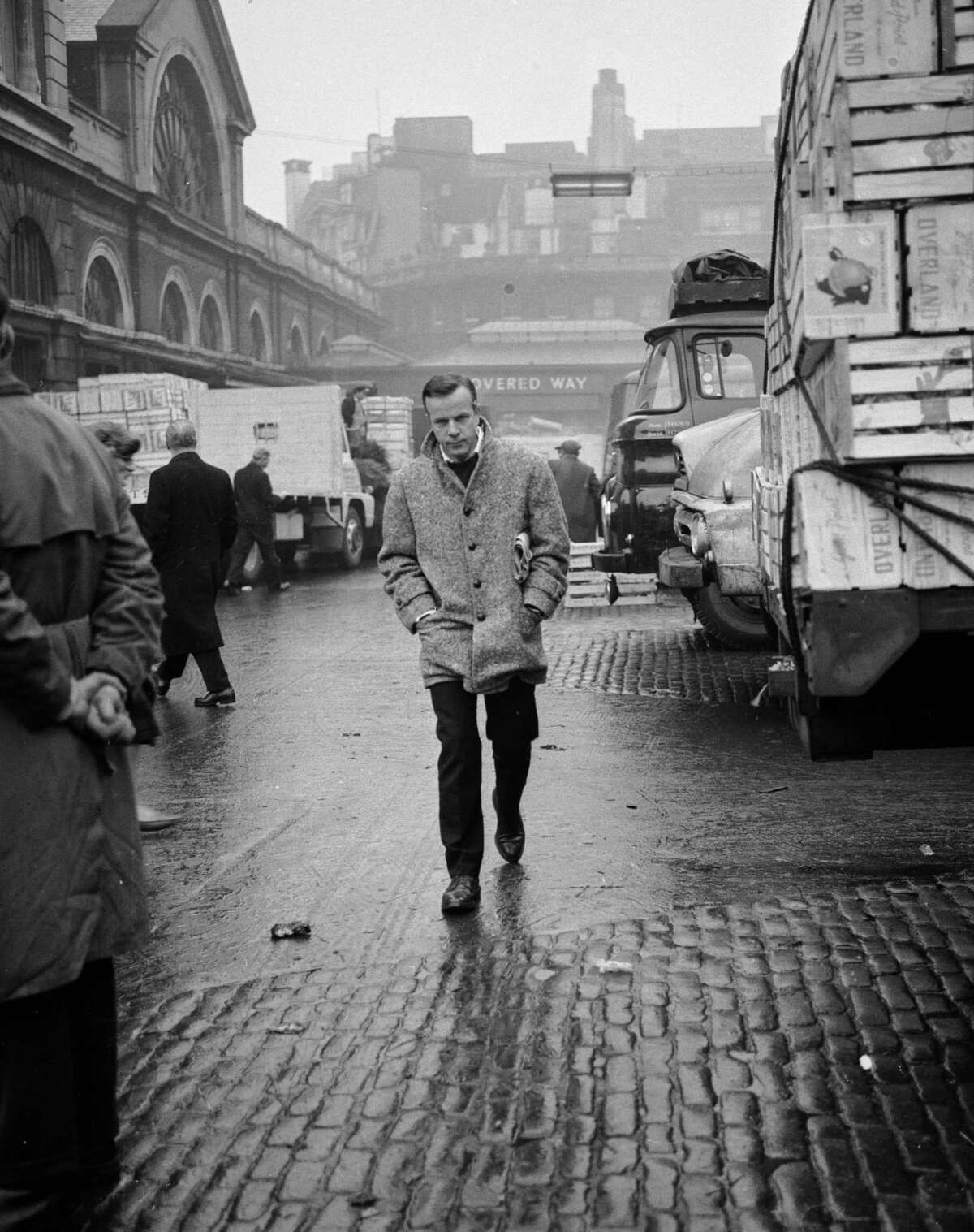 Italian conductor and film director Franco Zeffirelli, walking alone through Covent Garden market in London, January, 1964.