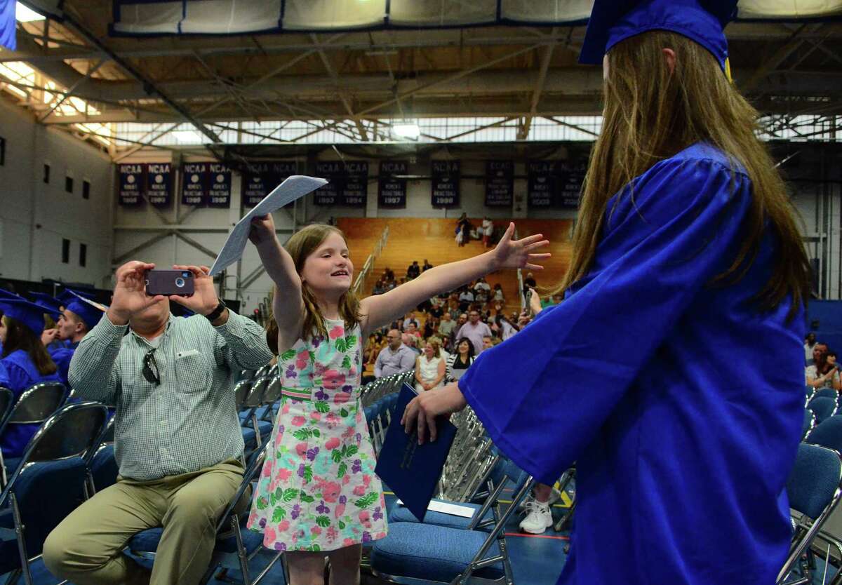 Fiona Killeen, 8, reaches out to hug her sister Courtney during Brookfield High School's 53rd Commencement Exercises at at the O'Neill Center at Western Connecticut State University in Danbury, Conn., on Saturday June 22, 2019.