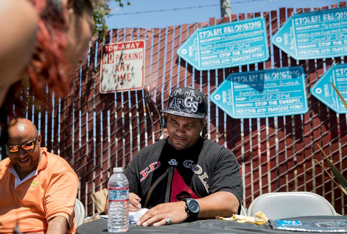 Unhoused resident Tyrone Shingledecker fills out a form identifying belongings taken from him by San Francisco's Department of Public Works including precious family jewelry during a protest highlighting San Francisco Department of Public Works' controversial practice of street sweeping and property confiscation held outside of San Francisco Department of Public Works yard in San Francisco, Calif. Friday, June 21, 2019.