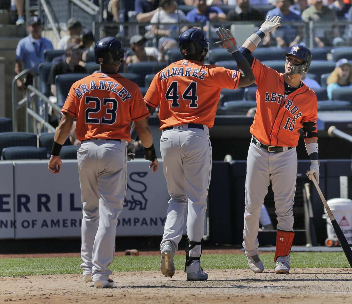Houston Astros' Yordan Alvarez, center, celebrates his two-run home run with Yuli Gurriel, right, and Michael Brantley (23) during the fifth inning of a baseball game against the New York Yankees at Yankee Stadium, Sunday, June 23, 2019, in New York. (AP Photo/Seth Wenig)