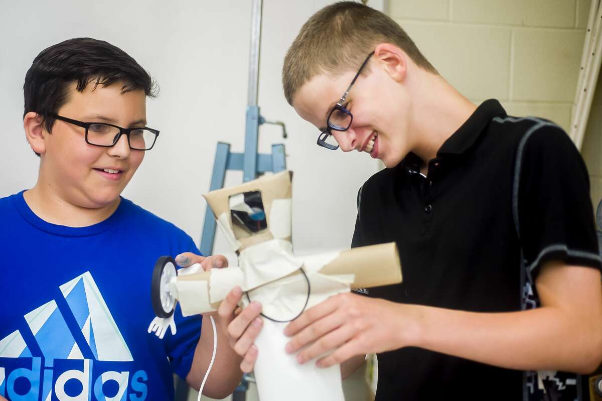 Chase Jaenicke, 12, left, and John Blizzard, 11, right, test out their moving sculpture during the first day of a week-long robotics camp at the Midland Center for the Arts on Monday, June 24, 2019. (Katy Kildee/kkildee@mdn.net)