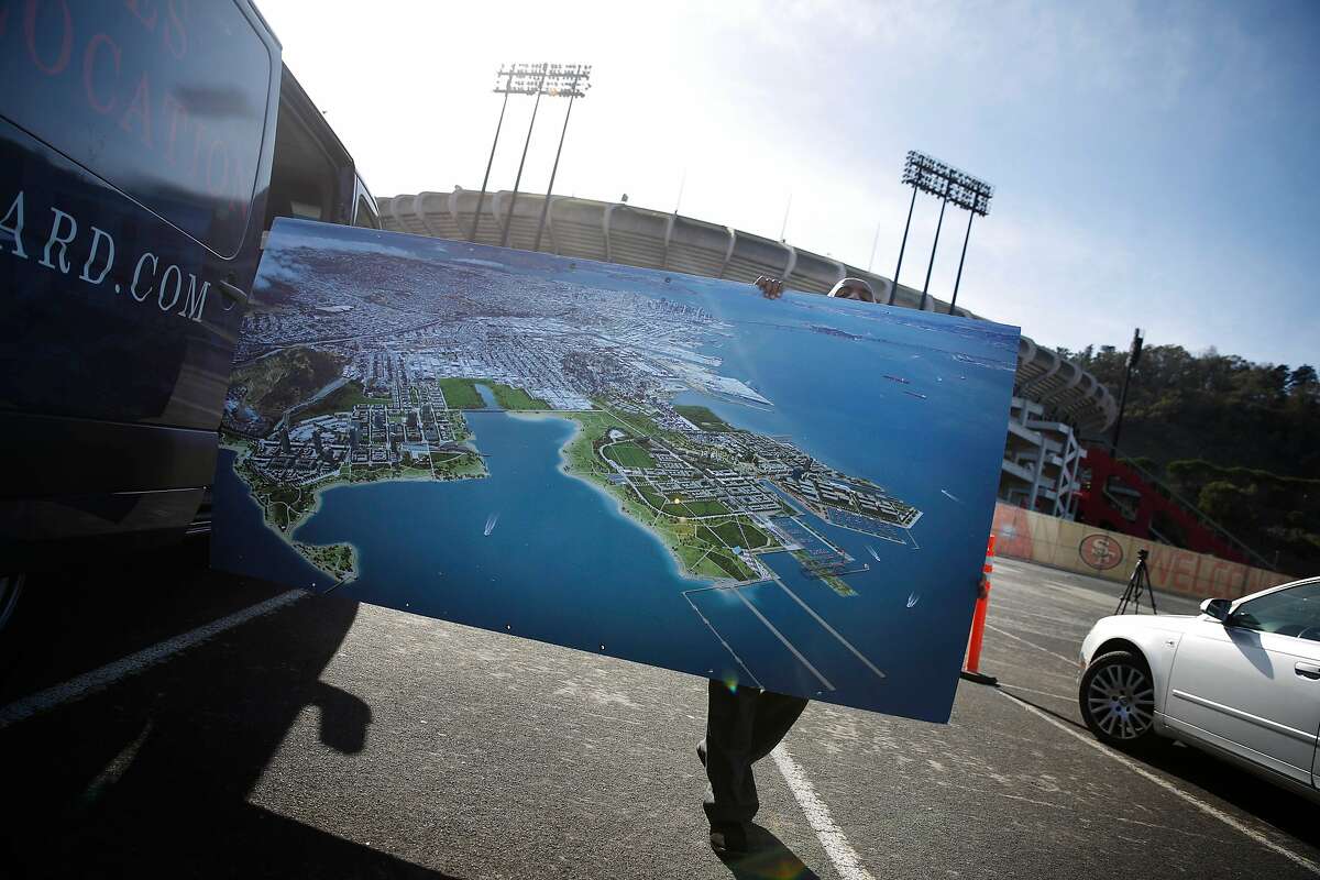 Tadesse Dereje, shuttle driver, puts a vision rendering for the Candlestick Point development project into a vehicle after a press conference in the Candlestick Park parking lot on Monday, November 17, 2014 in San Francisco, Calif.