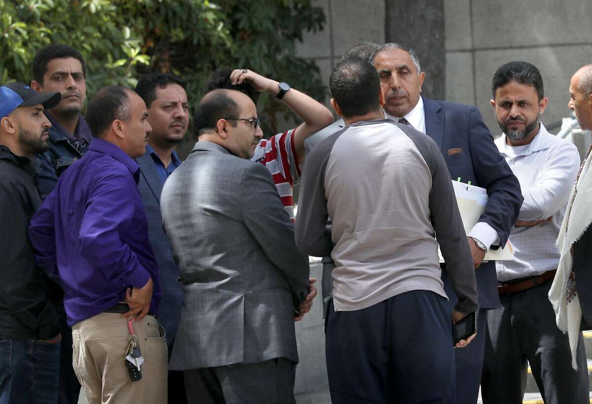 Yemeni consul general Mansoor Ismael (third from right) speaks with families and friends in front of the San Mateo courthouse on Monday, June 24, 2019, in San Mateo, Calif. They gathered after the arraignment of suspect Malik Dosouqi, 26, alleged to have possibly lured two men under false pretenses to a remote section of Hwy. 35 where he stabbed them to death.