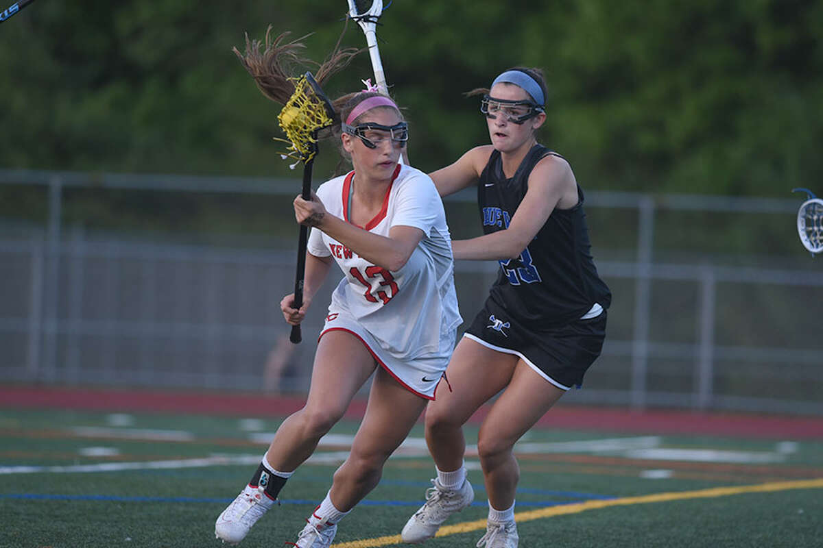 New Canaan's McKenna Harden (13) looks for room to move while Darien's Maddie Joyce (23) defends during the FCIAC girls lacrosse final Wednesday night at Testa Field in Norwalk. — Dave Stewart/Hearst Connecticut Media