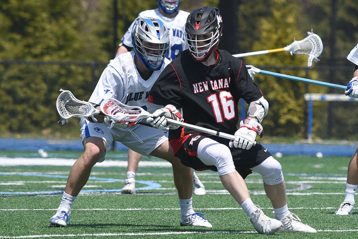 New Canaan's Will Rechtermann (16) battles Darien's Jack Joyce during the first quarter of Saturday's rivalry showdown at DHS. — Dave Stewart photo