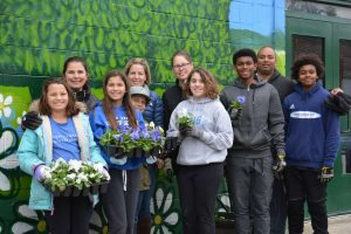 An Annual "Day of Service" at New Canaan Country School (NCCS), remembered a classmate. From left, Christina, Rochelle and Katey Charnin of Darien; Billy and Sanny Warner of New Canaan; Mary and Anna Majewski of Darien; Desmond ’17; and Dan and Mason Pratt of Trumbull, planted flowers at Open Door Shelter of Norwalk. — Contributed photo
