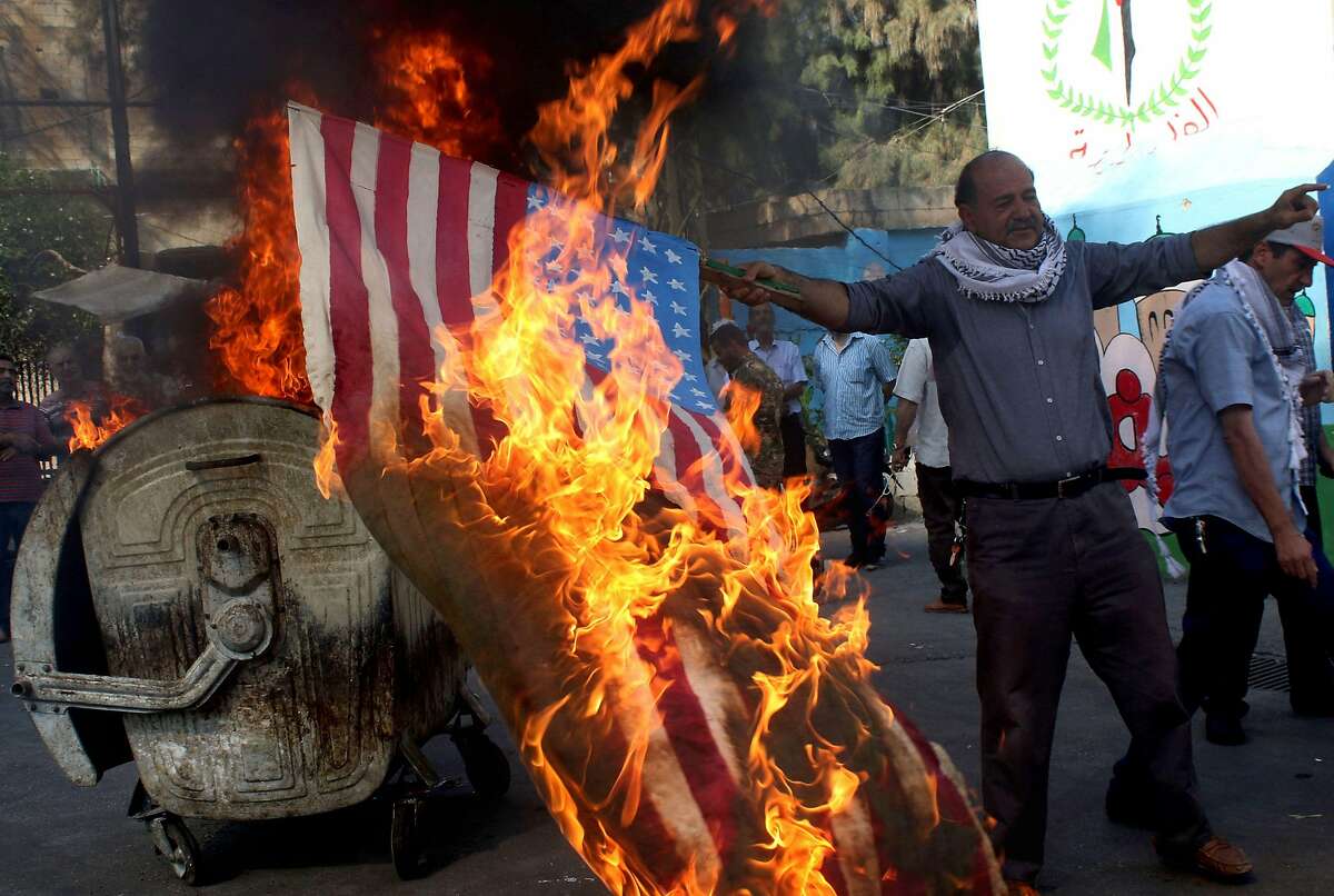 Palestinian refugees in Lebanon's southern Ain el-Helweh camp burn the US flag during a protest against a US-sponsored Middle East economic conference in Bahrain, on June 25, 2019. - The United States is set to co-chair a two-day conference in Bahrain from today focusing on the economic aspects of President Donald Trump's Israeli-Palestinian peace plan. The workshop in Manama will bring together government, civil society and business leaders, according to a joint statement by the two organising countries, with the declared aim of achieving Palestinian prosperity. (Photo by Mahmoud ZAYYAT / AFP)MAHMOUD ZAYYAT/AFP/Getty Images
