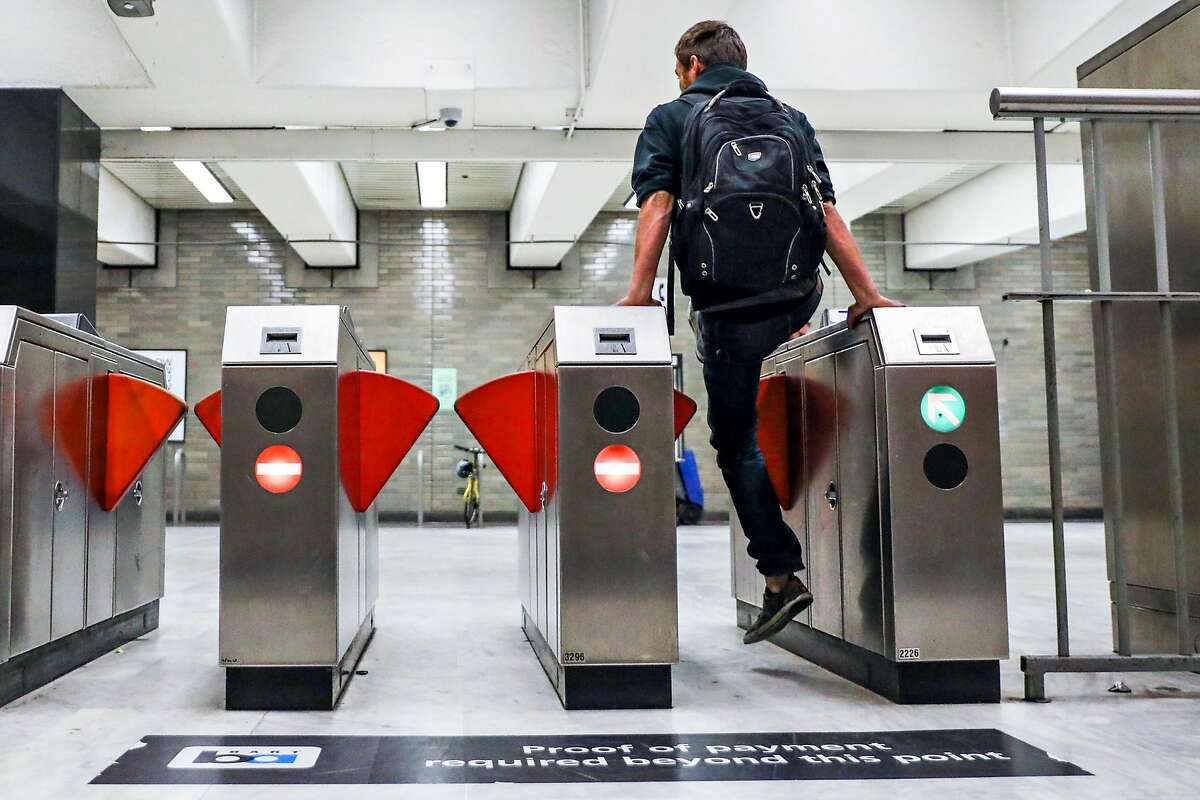 A man jumps the turnstile at the BART station at Civic Center despite gates that were installed (seen at left and right) to deter fare evasion in San Francisco, California, on Thursday, Aug. 16, 2018.