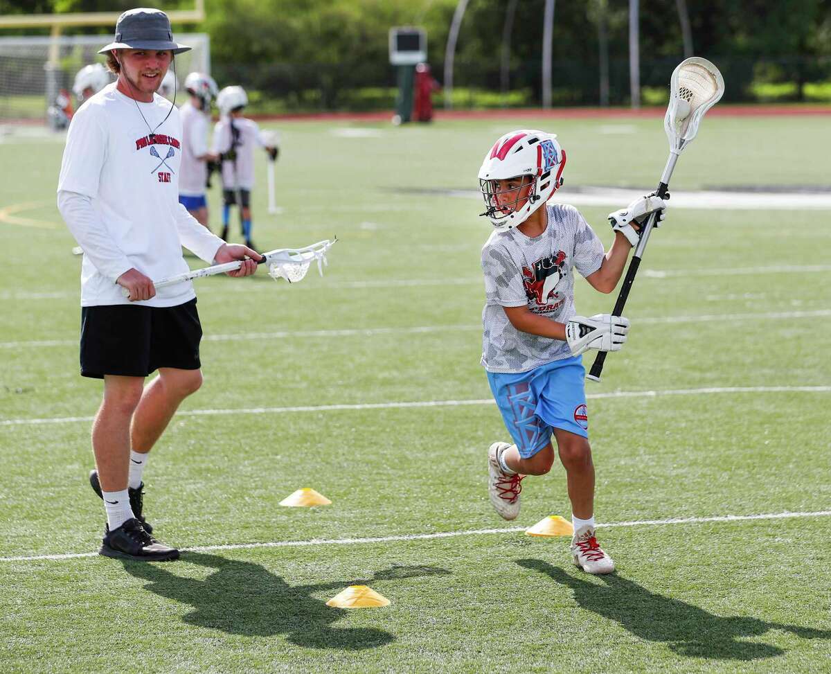 Sean Molyneux, left, works with Bryce Delgado on a shooting drill during the Myles Jones and Kylie Ohlmiller Pro Lacrosse camp at Fort Bend Christian Academy on Tuesday, June 18, 2019, in Sugar Land.