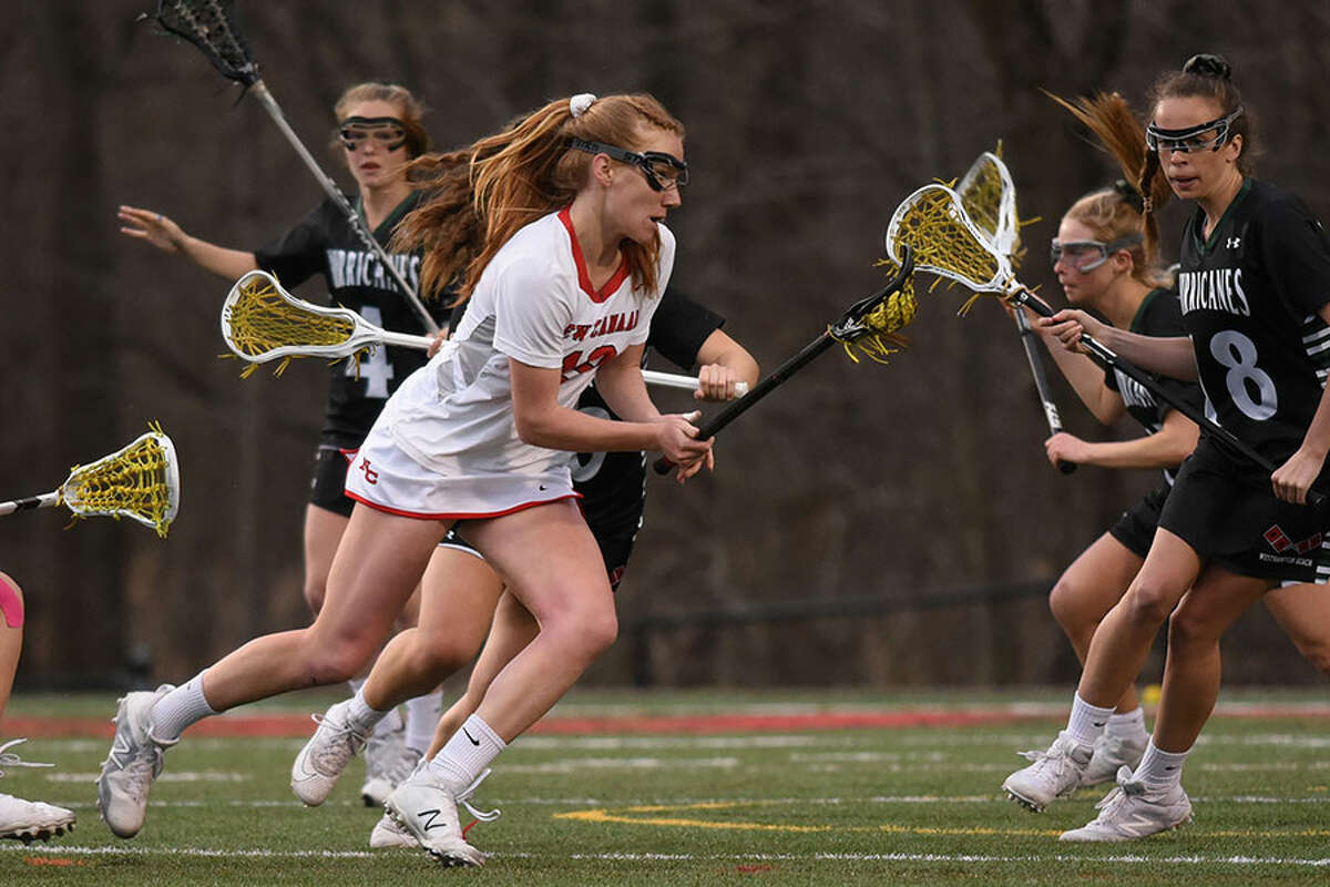 New Canaan’s Jane Charlton (19) battles the Westhampton Beach defense during a girls lacrosse game at Dunning Field on Friday. — Dave Stewart/Hearst Connecticut Media