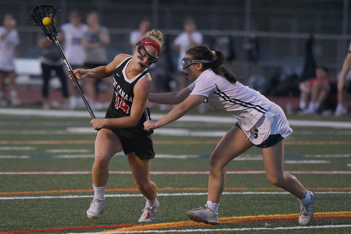 New Canaan’s Campbell Connors (14) drives while Staples’ Samantha Pacilio (8) defends during the FCIAC girls lacrosse semifinals at Norwalk’s Testa Field on Monday, May 20, 2019. — Dave Stewart/Hearst Connecticut Media
