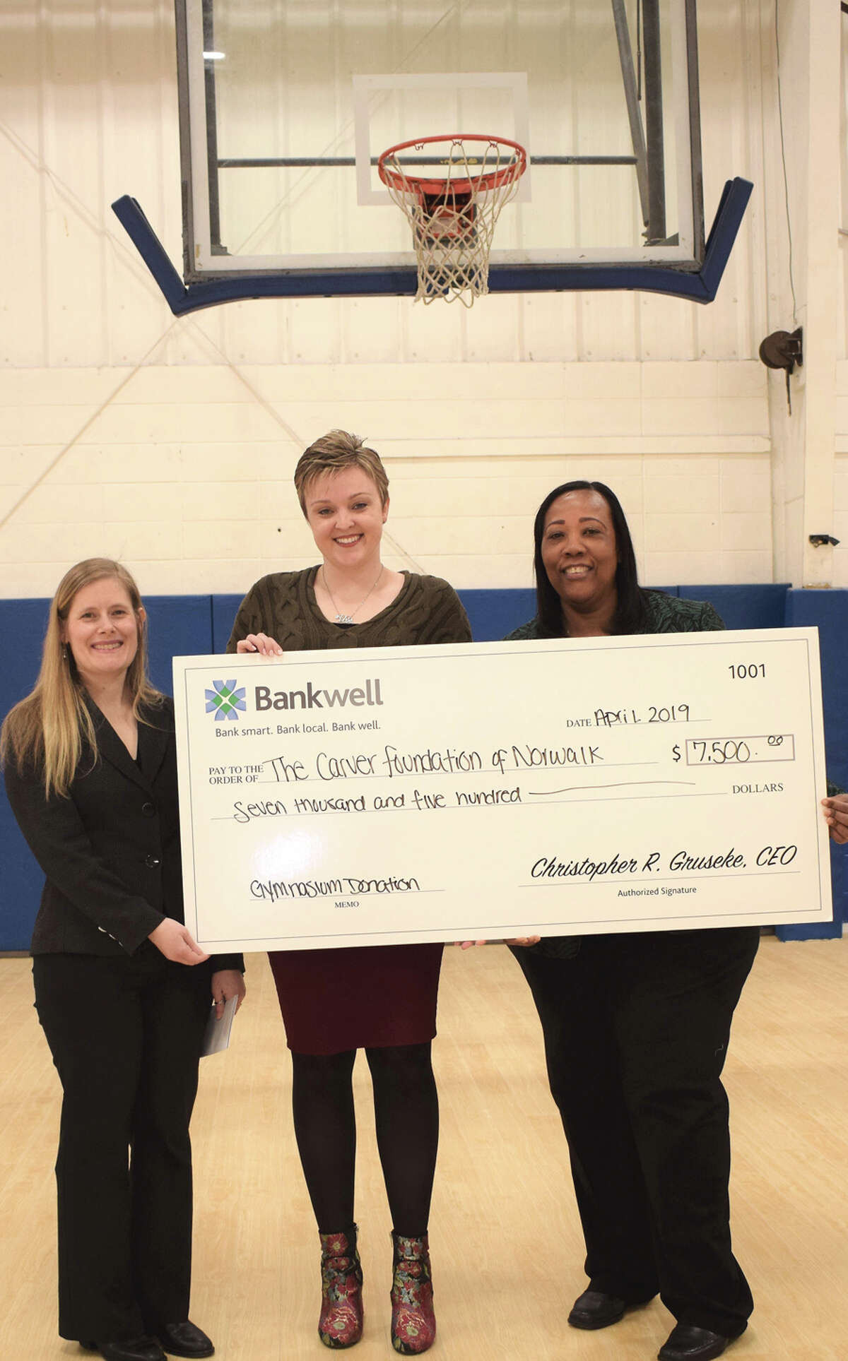 Nikki LaFaye, director of philanthropy at The Carver Foundation of Norwalk, Lucy French, assistant vice president and marketing manager at Bankwell, and Novelette Peterkin, CEO of the Carver Foundation of Norwalk, announce a $5,000 donation toward a gym expansion that will allow basketball programs to grow. Bankwell / Contributed photo