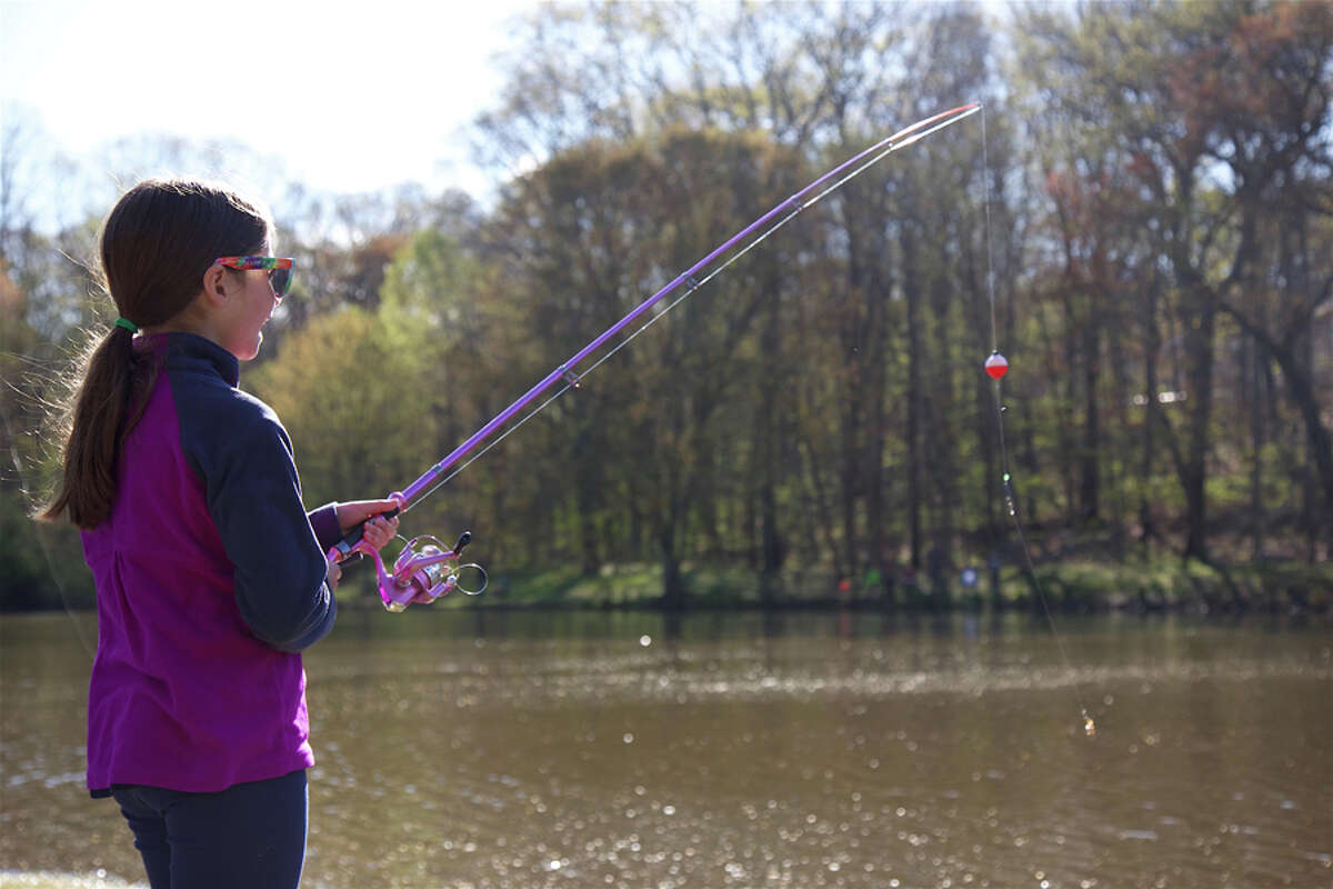 Abigail Greenhut, 9, of New Canaan, fishes on Mill Pond during the annual fishing derby, which was postponed to Saturday, April 27. Jarret Liotta / For Hearst Connecticut Media